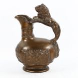 A 19th century heavy cast patinated bronze Roman style wine ewer, with lion handle and relief