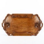 An Indian hardwood tray with relief carved bats and snakes, in moulded surround, length 60cm Good