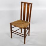 A Liberty style Art Nouveau beech sided chair, with inlaid back and rush seat, overall height 85cm