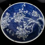 A large Chinese blue and white 'Prunus' charger, 19th century, decorated with underglaze blue,