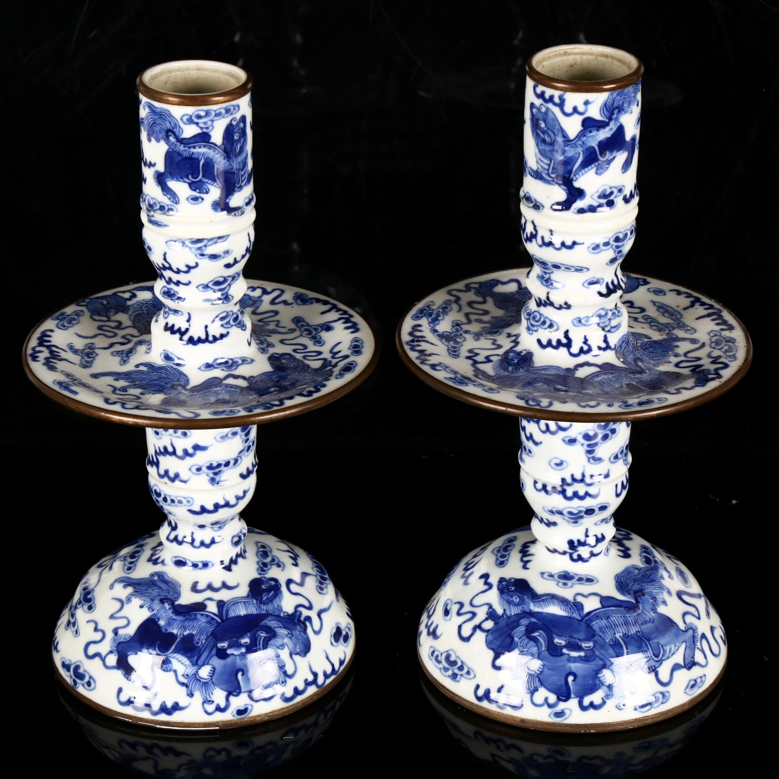 A pair of Chinese blue and white 'Dog of Fo' altar candlesticks, decorated in underglaze blue with