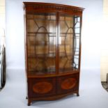 An Edwardian inlaid mahogany bow-front display cabinet in Sheritan style, with carved cornice and