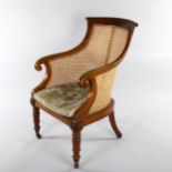 A 19th century mahogany-framed Bergere tub chair, on turned legs, with squab seat and brass