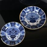 A graduated pair of 18th century Dutch Delft peacock pattern chargers, both marked, diameters 31cm