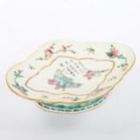 A Chinese oval porcelain dish on foot, with painted enamel decoration and text, length 23cm