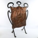 An Arts and Crafts wrought-iron and copper fire screen, with embossed panel, unsigned, height 78cm