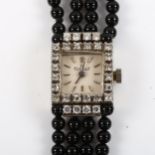 EXQUISIT - a lady's 18ct white gold diamond and jet mechanical cocktail bracelet watch, circa 1960s,