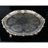 A large and heavy Victorian silver tray, circular form with lobed bead edge, central foliate