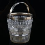 A George V silver-mounted glass ice bucket, with swing handle and pierced liner, armorial crest on