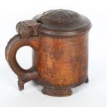 An 18th century Scandinavian birch peg tankard, with carved hinged lid, resting on 3 carved feet,