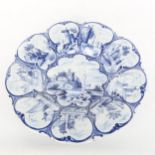 A 19th century Delft pottery cushion-shaped dish with painted panels, diameter 33cm A few tiny glaze