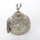 An unmarked Indian white metal box, with hinged lid and peacock knop, height 13cm, diameter 10cm