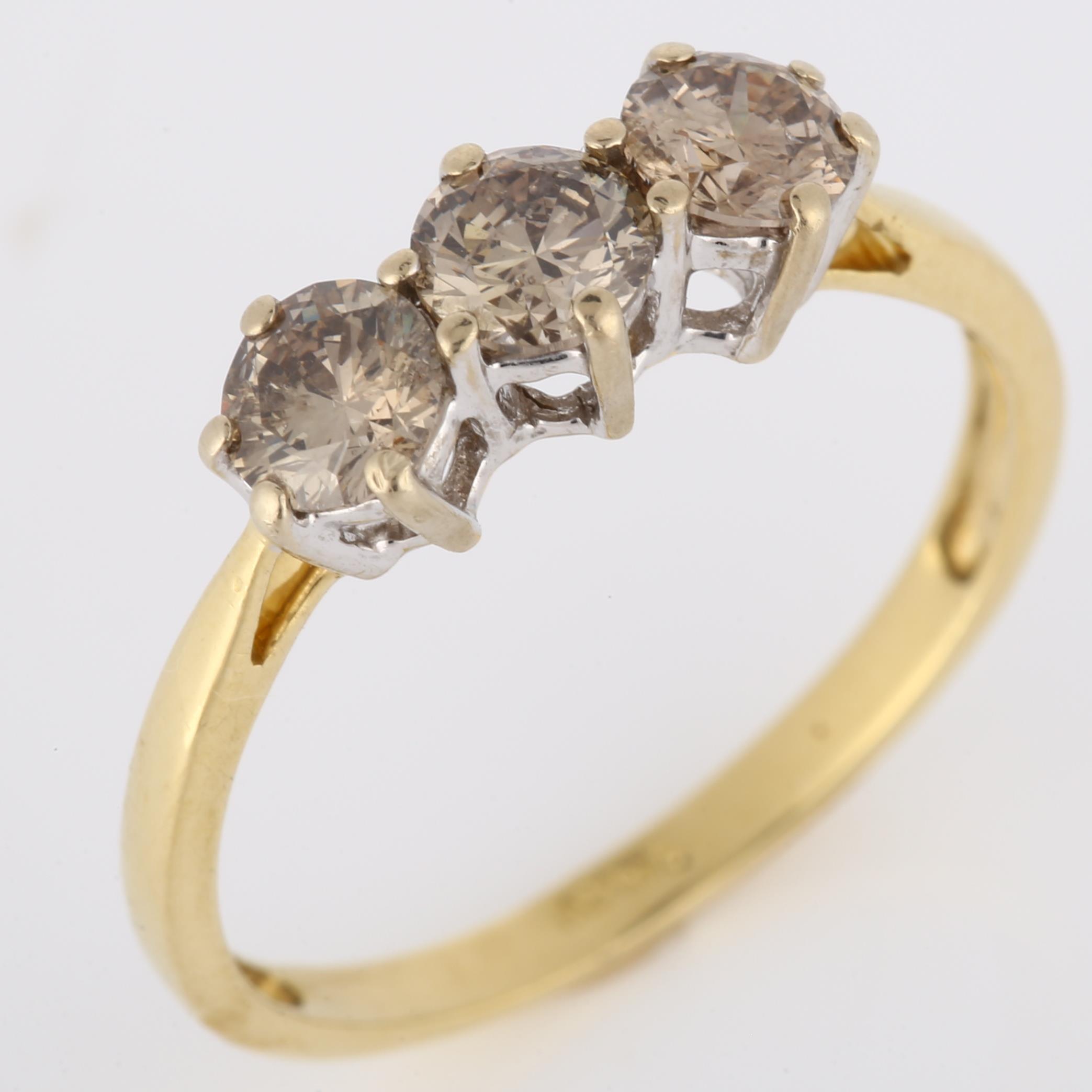 An 18ct gold three stone brown diamond ring, claw set with modern round brilliant-cut diamonds, - Image 2 of 4