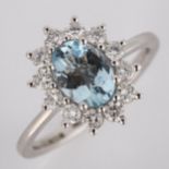 A modern 18ct white gold aquamarine and diamond cluster ring, set with oval mixed-cut aquamarine and