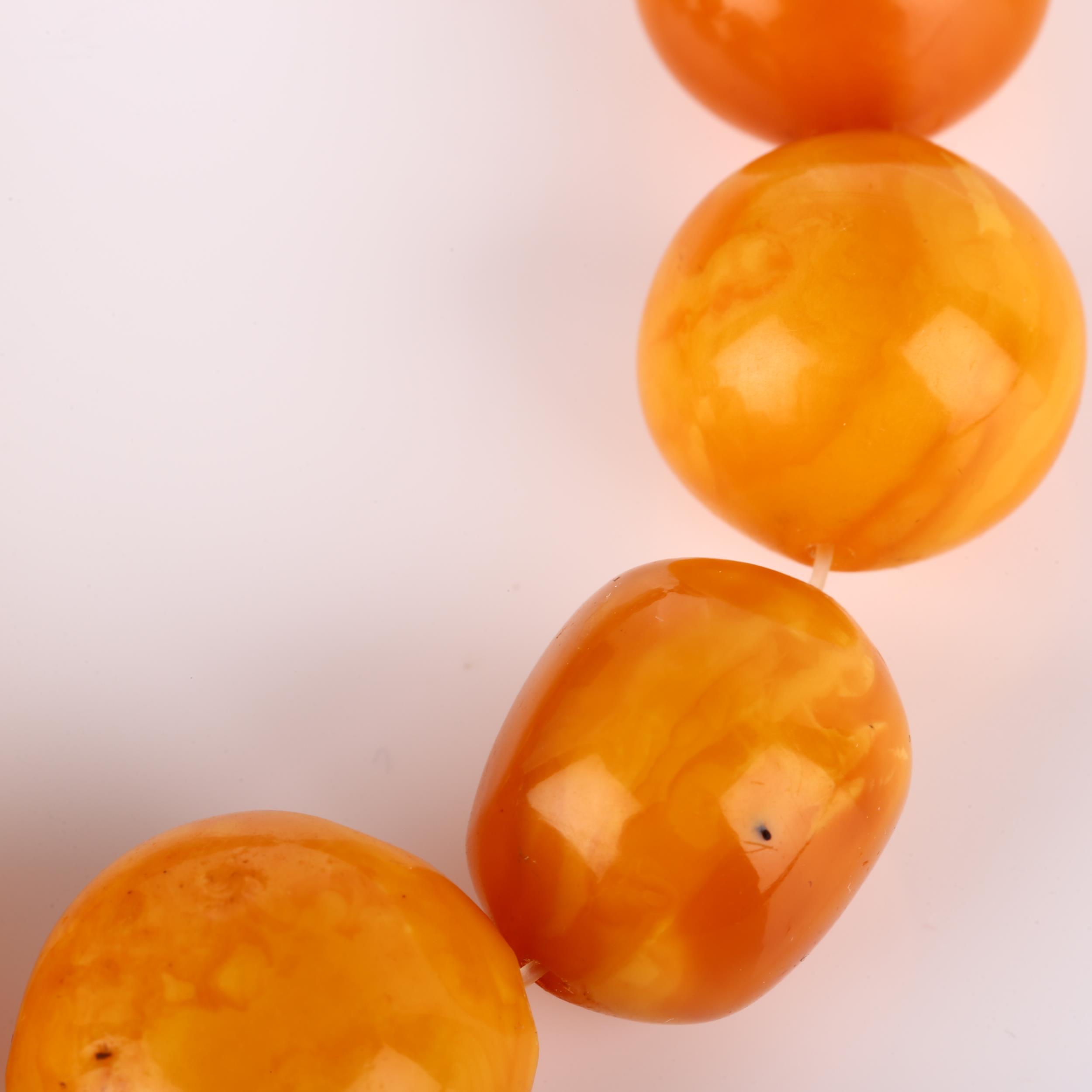 A graduated single-strand butterscotch amber bead necklace, beads ranging from 26.9mm to 23mm, - Bild 2 aus 4