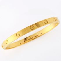 CARTIER - an 18ct gold 'LOVE' bangle, with screw-head motifs, signed Cartier, serial no. BD6544,