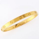 CARTIER - an 18ct gold 'LOVE' bangle, with screw-head motifs, signed Cartier, serial no. BD6544,