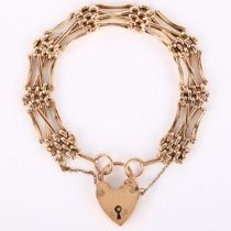 An early/mid-20th century unmarked rose gold gatelink bracelet, with 9ct heart padlock clasp,