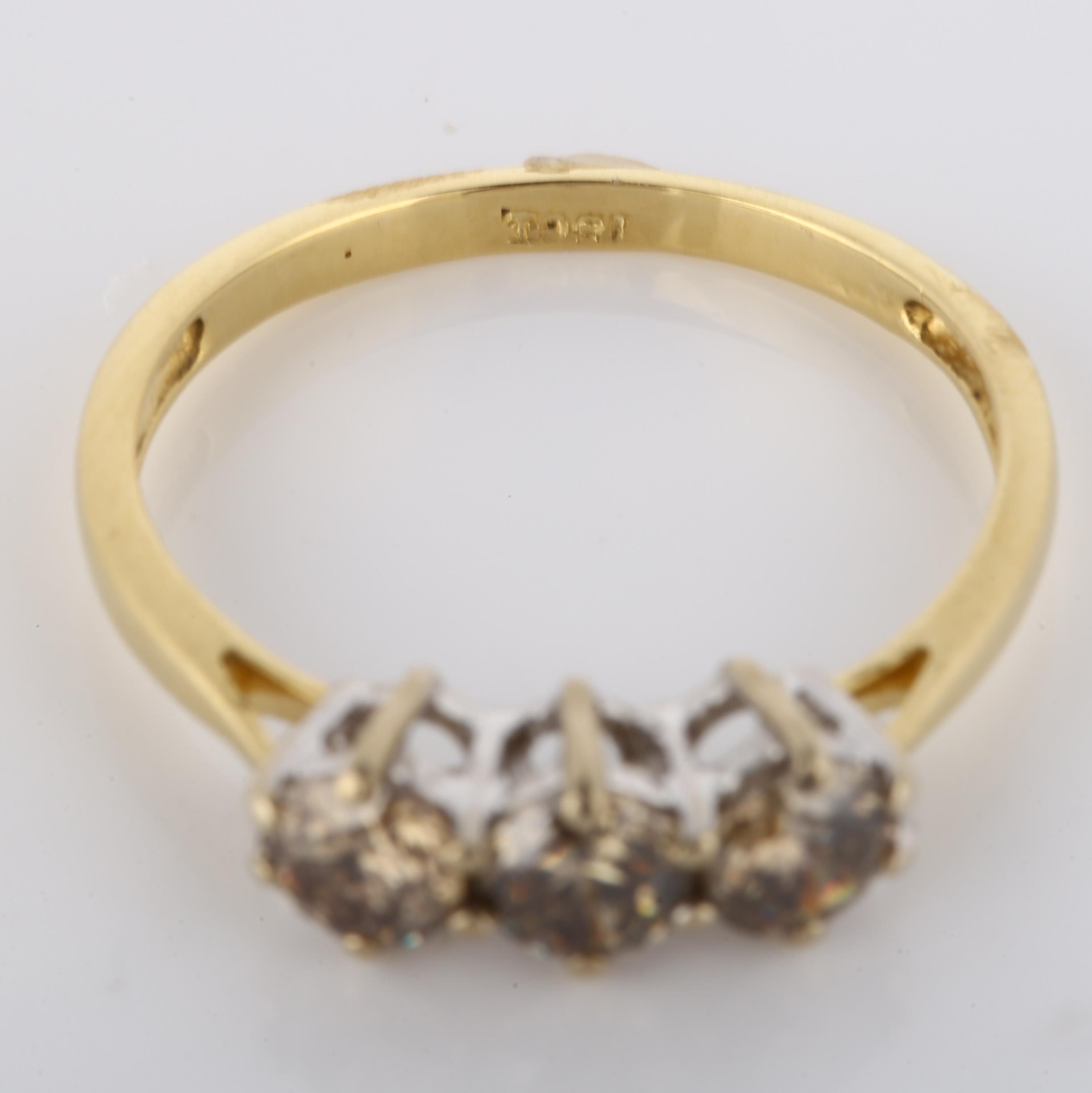 An 18ct gold three stone brown diamond ring, claw set with modern round brilliant-cut diamonds, - Image 3 of 4