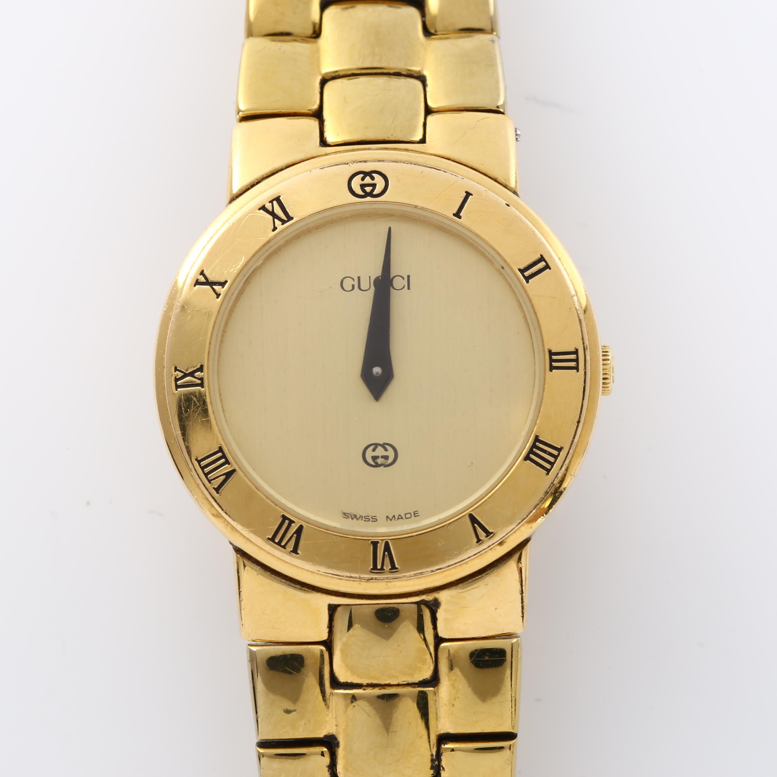 GUCCI - a lady's gold plated 3300L quartz bracelet watch, champagne dial with blue hands and Roman