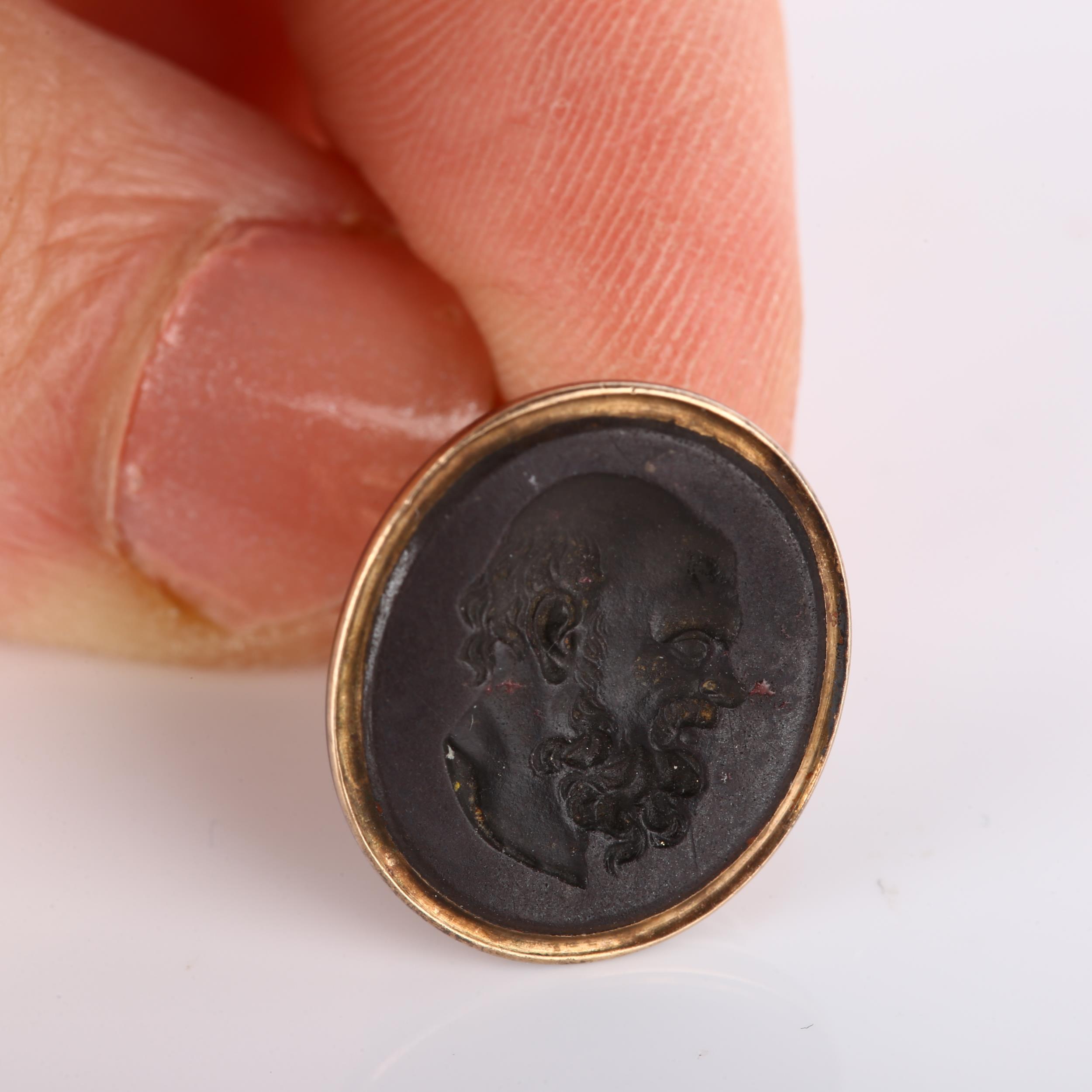 An Antique hardstone ring stone, intaglio carved depicting Aristotle, in unmarked gold fob mount, - Bild 2 aus 4