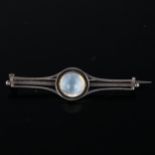 An Arts and Crafts moonstone bar brooch, unmarked silver settings with round high cabochon