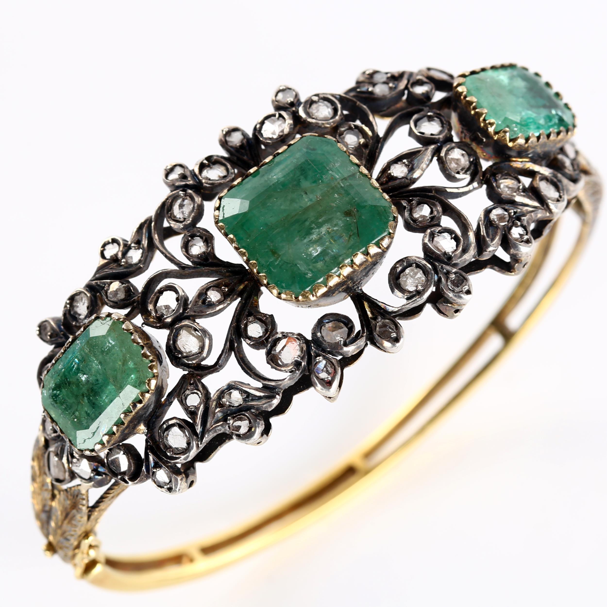 A fine Victorian emerald and diamond hinged bangle, unmarked gold and silver-topped openwork