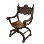 A 19th century Italian walnut X-framed armchair, with relief carved mask decoration Woodwork is