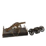 A brass model cannon on wood base, length 31cm, and a pair of smaller painted brass model cannons