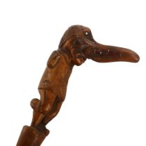 A 19th century novelty walking stick, the handle carved in the form of a one-legged man with a big