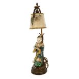 A Japanese 19th century porcelain figure of a man holding a book, mounted on a gilt-metal lamp