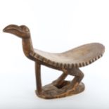 An African Tribal stool in the form of a bird, carved from a single piece of wood, length 62cm A few