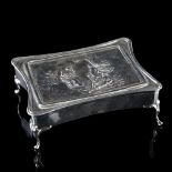 A large Edwardian silver dressing table jewel box, shaped rectangular form with relief embossed