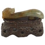 A Chinese carved jade dragon design buckle on hardwood stand, length 8cm Good condition