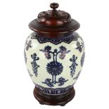 An 18th century Chinese blue Docai porcelain jar with carved and pierced hardwood cover and stand,