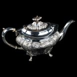 A late Victorian silver teapot, shaped oval form with relief embossed foliate decoration and ivory