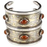 A large central Asian Turkoman carnelian wrist cuff, brass overlaid unmarked white metal settings,