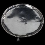 A George III silver salver, circular form with bead edge, raised on claw and ball feet, by Robert