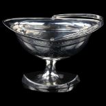 An Irish George III silver boat-shaped swing-handled sugar basket, bright-cut engraved floral swag