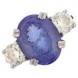 A platinum three stone tanzanite and diamond ring, set with oval mixed-cut tanzanite and modern