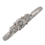 A platinum three stone diamond ring, prong set with modern round brilliant-cut diamonds, total