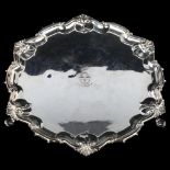 A George V silver salver, circular form with piecrust edge and foliate border, with engraved