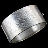A large Victorian silver hinged bangle, engraved floral decoration, band width 31.3mm, internal