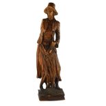 A 19th century carved stained wood figure wearing a hat, height 69cm