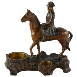 A 19th century patinated metal smoker's stand, surmounted by a figure of Napoleon on horseback,