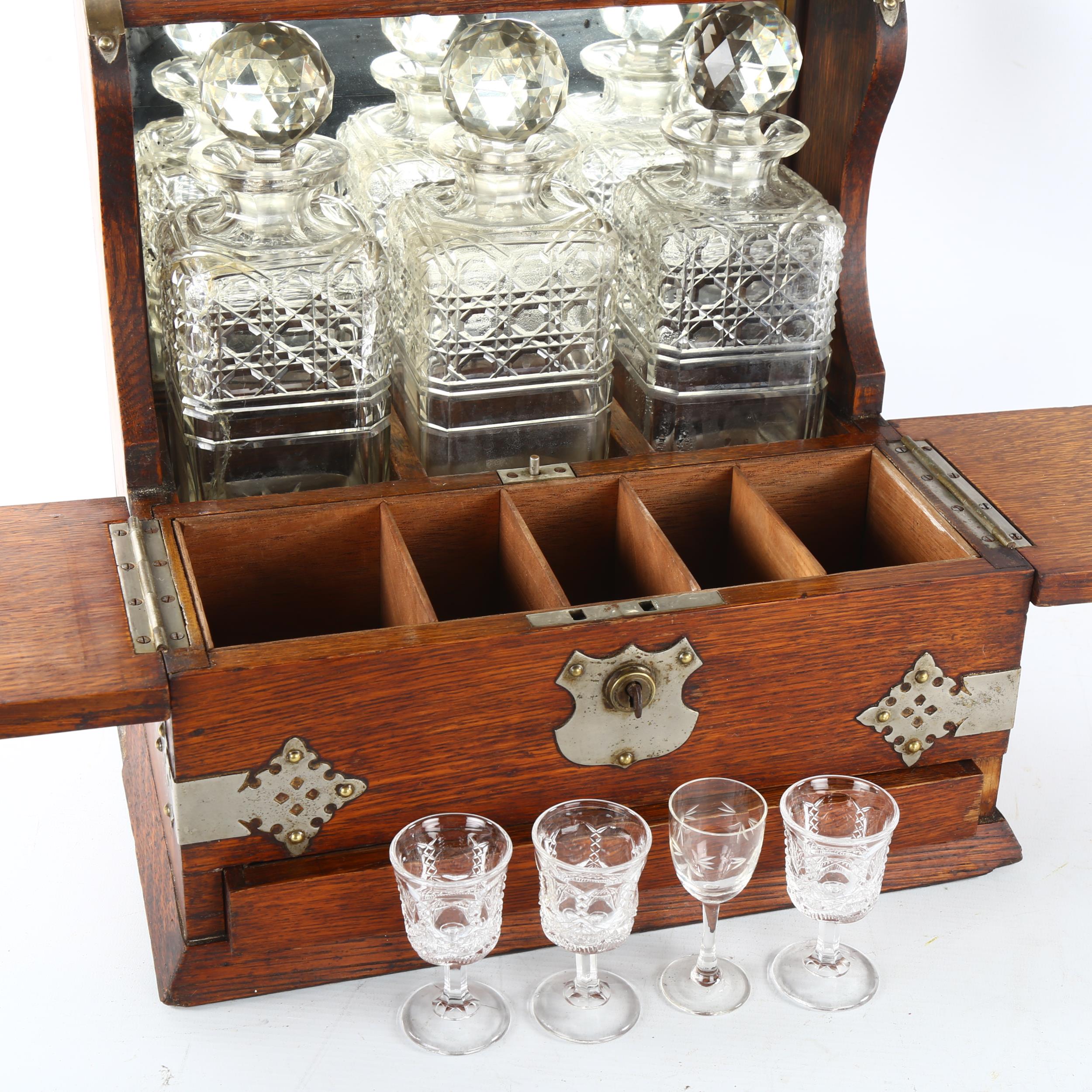 An Edwardian 3 decanter oak tantalus, Gothic metal mounts, with glass cabinet, cribbage board drawer - Image 3 of 3