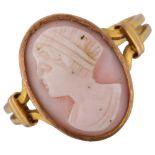 A pink coral cameo ring, unmarked gold settings with relief carved panel depicting female profile,