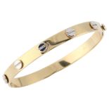 A modern 9ct two-colour gold hinged bangle, with screw-head motifs, band width 6.5mm, internal