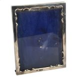 An Edwardian silver rectangular strut photo frame with shaped interior edge, by Andrew Barrett &