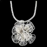 A large modern handmade sterling silver flowerhead pendant necklace, wirework design, by Claude